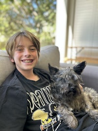 a boy sitting on a couch with a dog